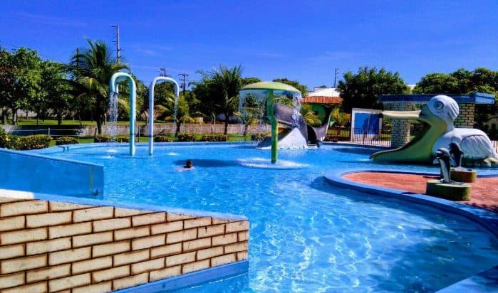 Piscina do Torre do Sol com brinquedos aquáticos, escorregadores e palmeiras